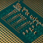 Close-up de um microprocessador montado em uma placa de circuito, com trilhas e componentes eletrônicos visíveis.