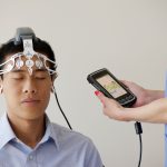 Profissional de saúde realiza um exame de eletroencefalograma em um paciente usando um dispositivo de monitoramento cerebral.