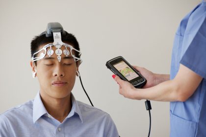 Profissional de saúde realiza um exame de eletroencefalograma em um paciente usando um dispositivo de monitoramento cerebral.