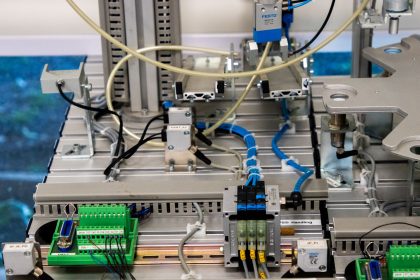 Close-up de equipamentos industriais com fiação eletrônica e sensores em uma instalação de manufatura.
