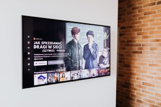 Televisão inteligente exibindo conteúdo de streaming em uma sala de estar moderna com parede de tijolos aparentes