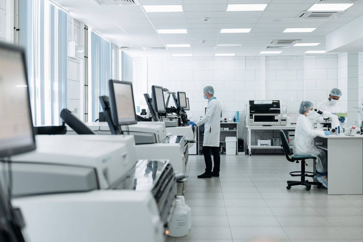 Pesquisadores realizam análises em um laboratório biomédico equipado com instrumentos científicos.