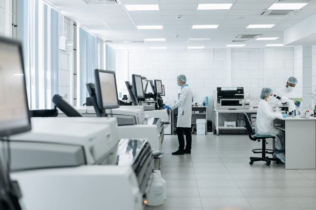Pesquisadores realizam análises em um laboratório biomédico equipado com instrumentos científicos.